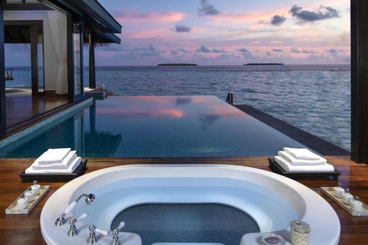 Sunset view from bathroom of over water pool villa