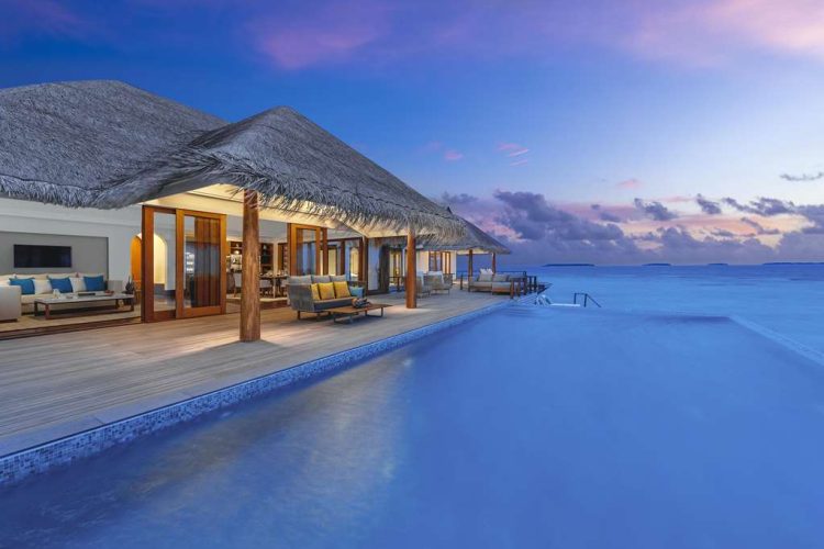 Swimming pool and outdoor deck of residence at sunset