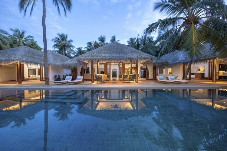 Exterior view of Three Bedroom Beach Pool Residence over swimming pool with sun-loungers and palm tr