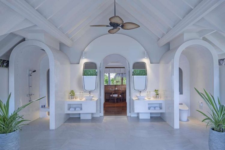 Interior view of bathroom in Beach Pool Residence with two sinks and bedroom view