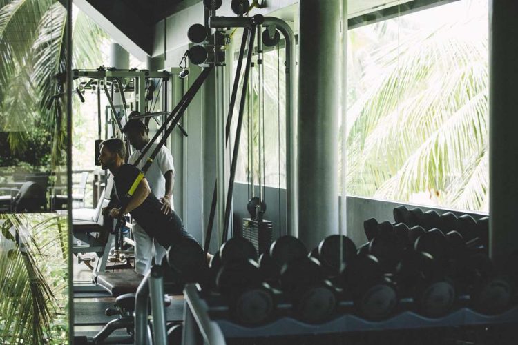 Guest working out with trainer in gym