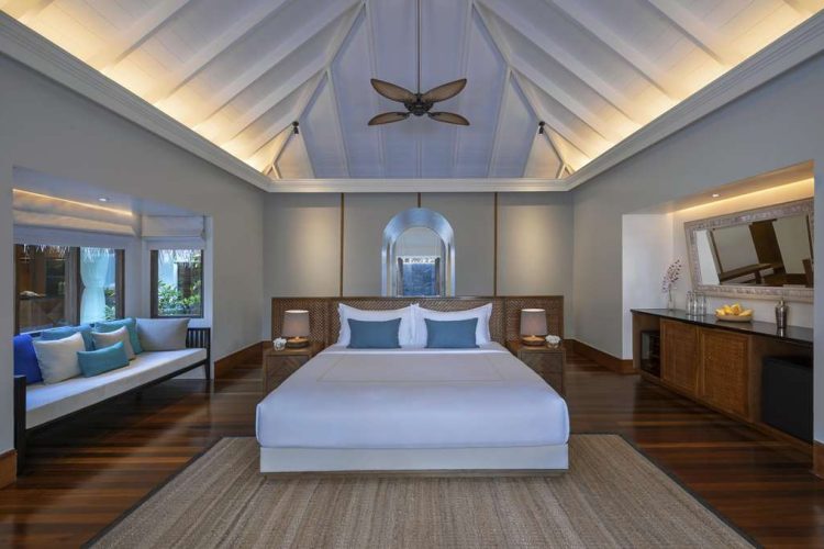 Interior view of master bedroom in Beach Pool Residence with seating area and mini-bar cabinet