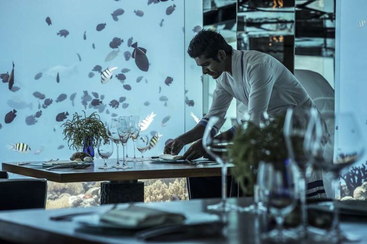 Team member arranging a table at Sea Underwater Restaurant